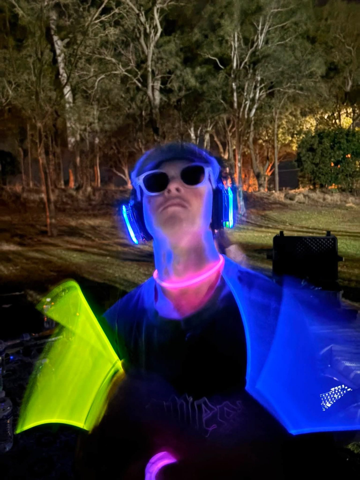 A guest in glow sticks and headphones at a Silent Sets night rave