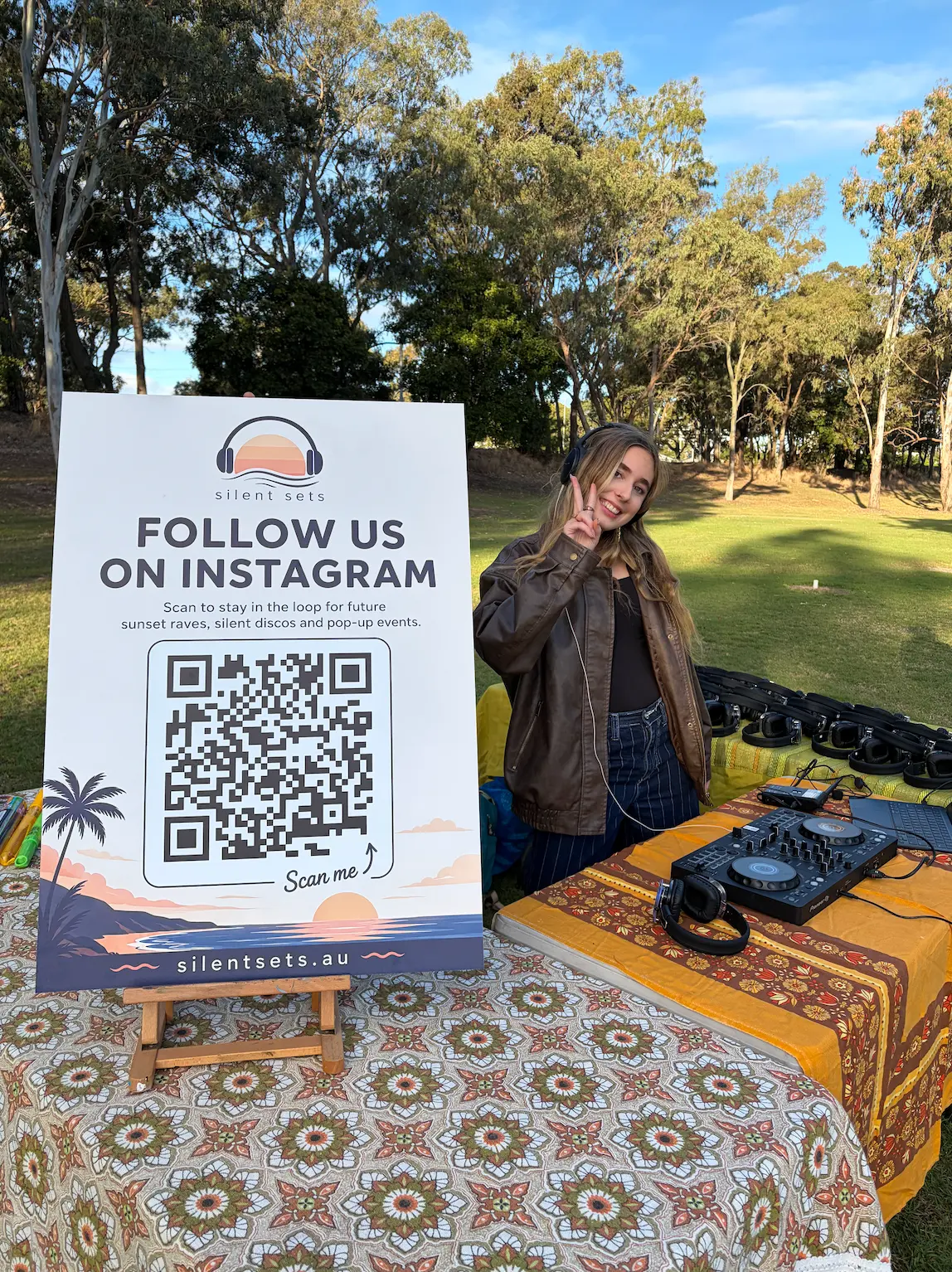 EDN DJ standing beside the Silent Sets Instagram sign at a park pop-up
