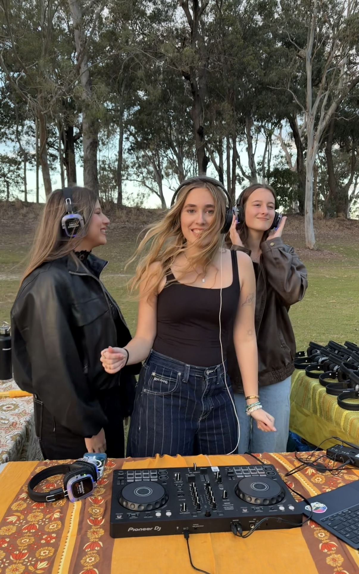 EDN DJ and friends in headphones behind the decks at a Silent Sets park pop-up